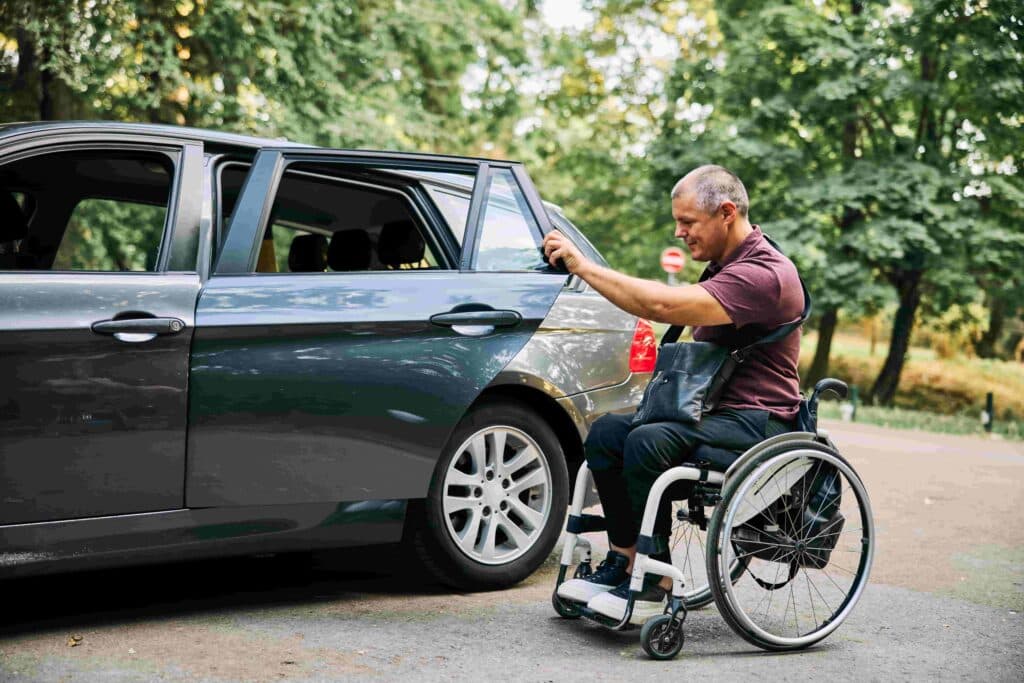 Driver assisting a wheelchair passenger into an accessible vehicle